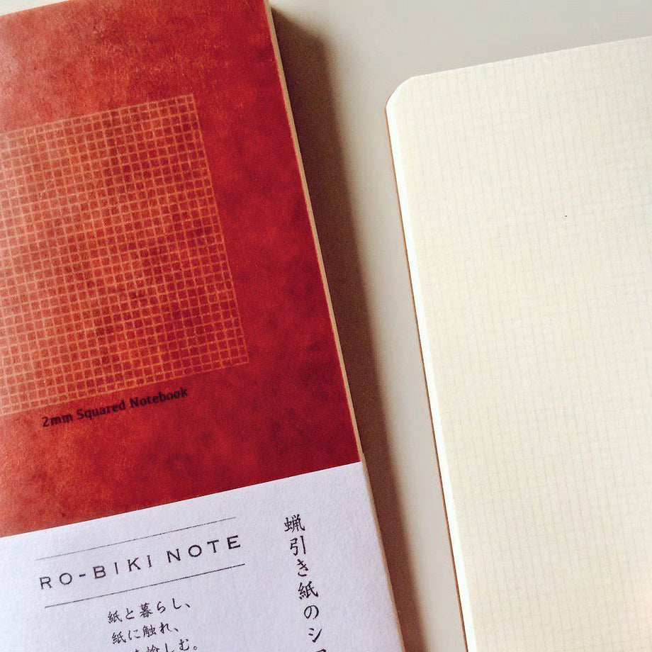 The RO‑BIKI Note is a beautifully crafted Japanese notebook known for its distinctive waxed paper cover, which gains character the more you use it. Over time, the cover softens, develops a natural patina, and becomes uniquely yours—making every notebook feel personal and well‑loved.
Inside, you’ll find high‑quality 2mm square grid paper ideal for writing, sketching, planning, or journaling. Its compact size makes it perfect for everyday carry, while the durable construction ensures it holds up to frequent