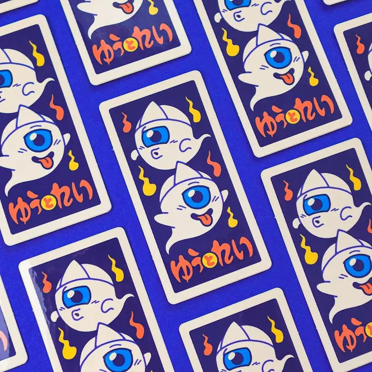 This illustration is inspired by Menko cards, an ancient Japanese game similar to the Pog game. The cards, made of more or less thick cardboard, were usually illustrated with characters from manga/TV series/movies, or athletes (mainly baseball players and sumos).
On this menko we can see Yû and Rei (), the little ghosts, two of our original characters.
The white triangle on their foreheads is called hitaikakushi and is a traditional attribute of yûrei (Japanese ghosts).
• Vinyl sticker
• 4.5 x 8.8 cm
• PV