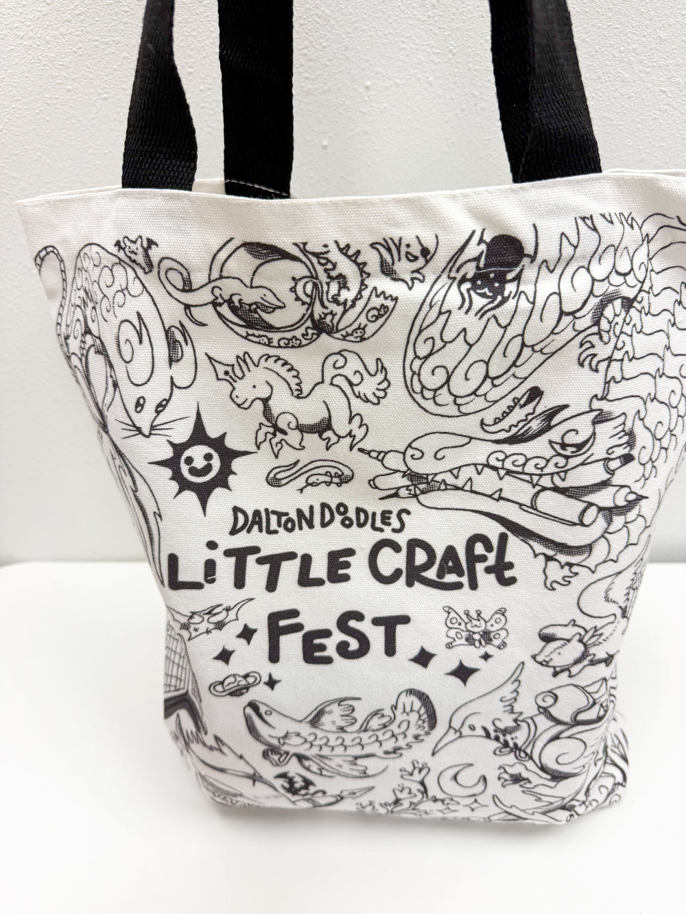 Carry a little magic everywhere you go.
This exclusive Little Craft Fest x Dalton Doodles tote bag celebrates the debut of Dalton’s newest universe, a whimsical world where everyday stationery transforms into mystical creatures. Featuring Dalton’s first sketch from the series, this tote brings charm, creativity, and a spark of imagination to your daily routine.