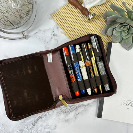 Indulge in the epitome of elegance with the Girologio 12 Zippered Pen Case. Meticulously crafted from premium, eco-friendly tanned leather, this zippered case promises a lavish velvet interior and generous space to securely accommodate up to 12 pens. Girologio once again emerges as a superior choice for safeguarding your cherished writing instruments, seamlessly combining plush softness and flexibility with unparalleled toughness and durability.