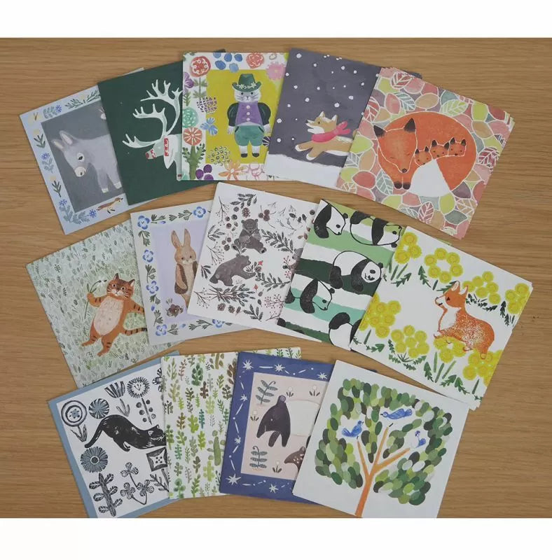 Collection of animal-themed greeting cards on a wooden surface