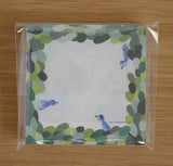 Note card with bird design on a wooden surface