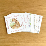 Set of greeting cards with a cat illustration on a wooden surface