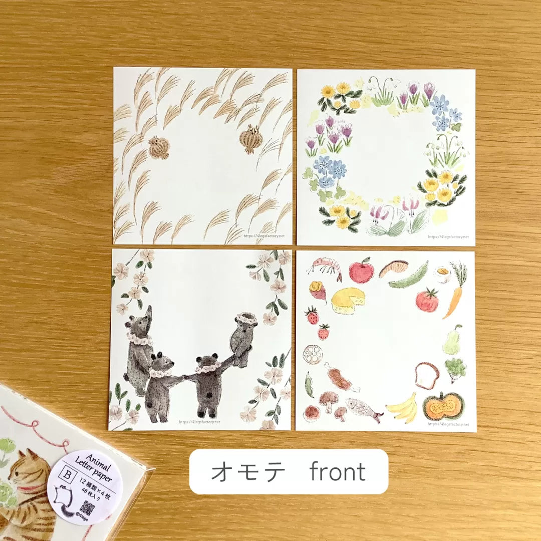 Set of four decorative paper sheets with floral, nature, and animal designs on a wooden surface.