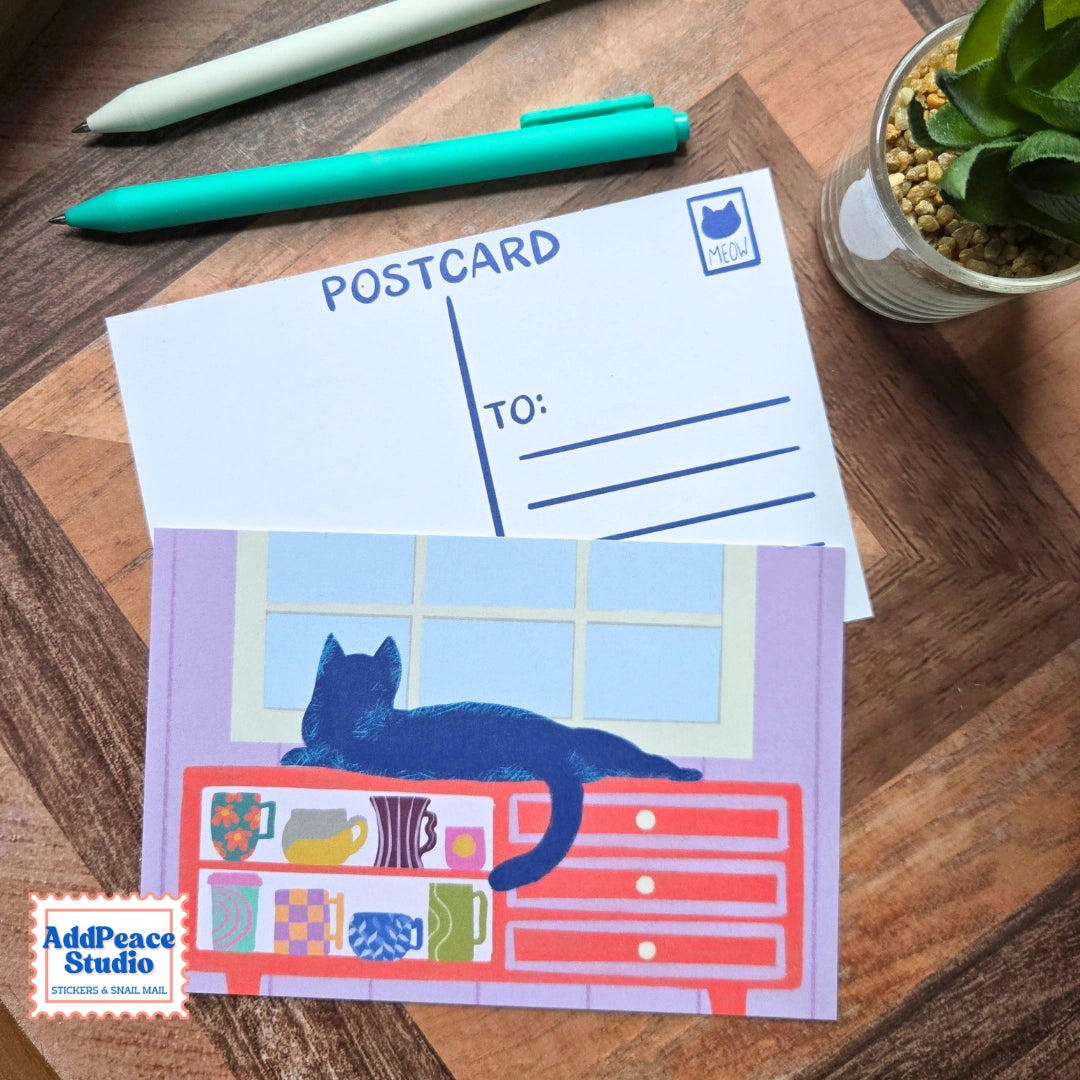 AddPeace Studio - Cats &amp; Cups Postcard Pack

A charming illustrated postcard set for cat lovers, homebodies, and anyone craving a little analog joy. This Cats &amp; Cups postcard pack celebrates quiet moments, warm drinks, and the simple pleasure of sending real mail. Designed for the current resurgence of snail mail, pen pals, and intentional connection, these postcards make it easy (and fun) to go offline on purpose.

Each set includes ten unique 4x6 postcards featuring original Cats &amp; Cups illust