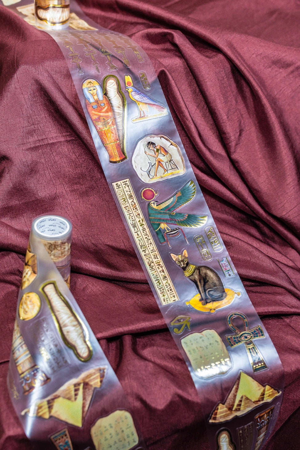 A unique extra large transparent tape design by CoraCreaCrafts. This tape features beautiful designs to transport you back in time to Ancient Egypt and the world of Pharaohs.Features: Super convenient, premium pre-cut designs, easy to peel off like stickers, beautiful gold foil detailing 
Size: 10cm wide × 5m long with a 100cm repeat (that means you get 5 times 1 full meter of completely different designs!)