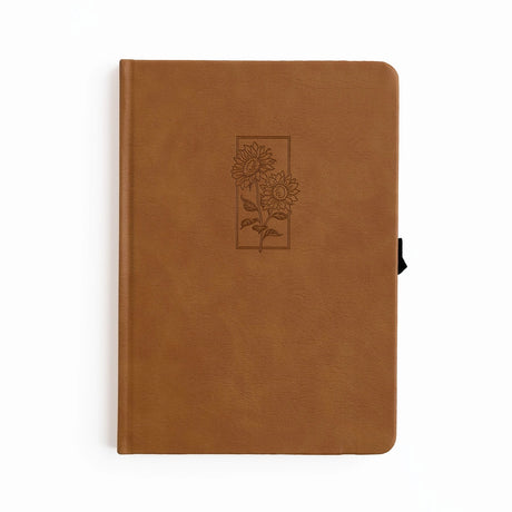 Let your ideas bloom with this warm and inviting Sunflower Notebook. Wrapped in a rich caramel vegan leather cover, it features a beautifully debossed pair of sunflowers—symbols of joy, hope, and creative energy. Whether you're journaling your thoughts or planning your next big project, this notebook brings a little sunshine to every page.

✨&nbsp;Features You’ll Love

Elegant debossed sunflower illustration&nbsp;for a clean, understated botanical look

Caramel vegan leather cover&nbsp;that’s soft to the to