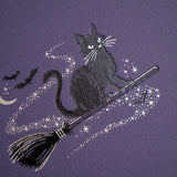 The Bewitched Notebook captures the playful spirit of Halloween with a charming black cat perched atop a broomstick beneath a crescent moon, surrounded by twinkling stars and fluttering bats.