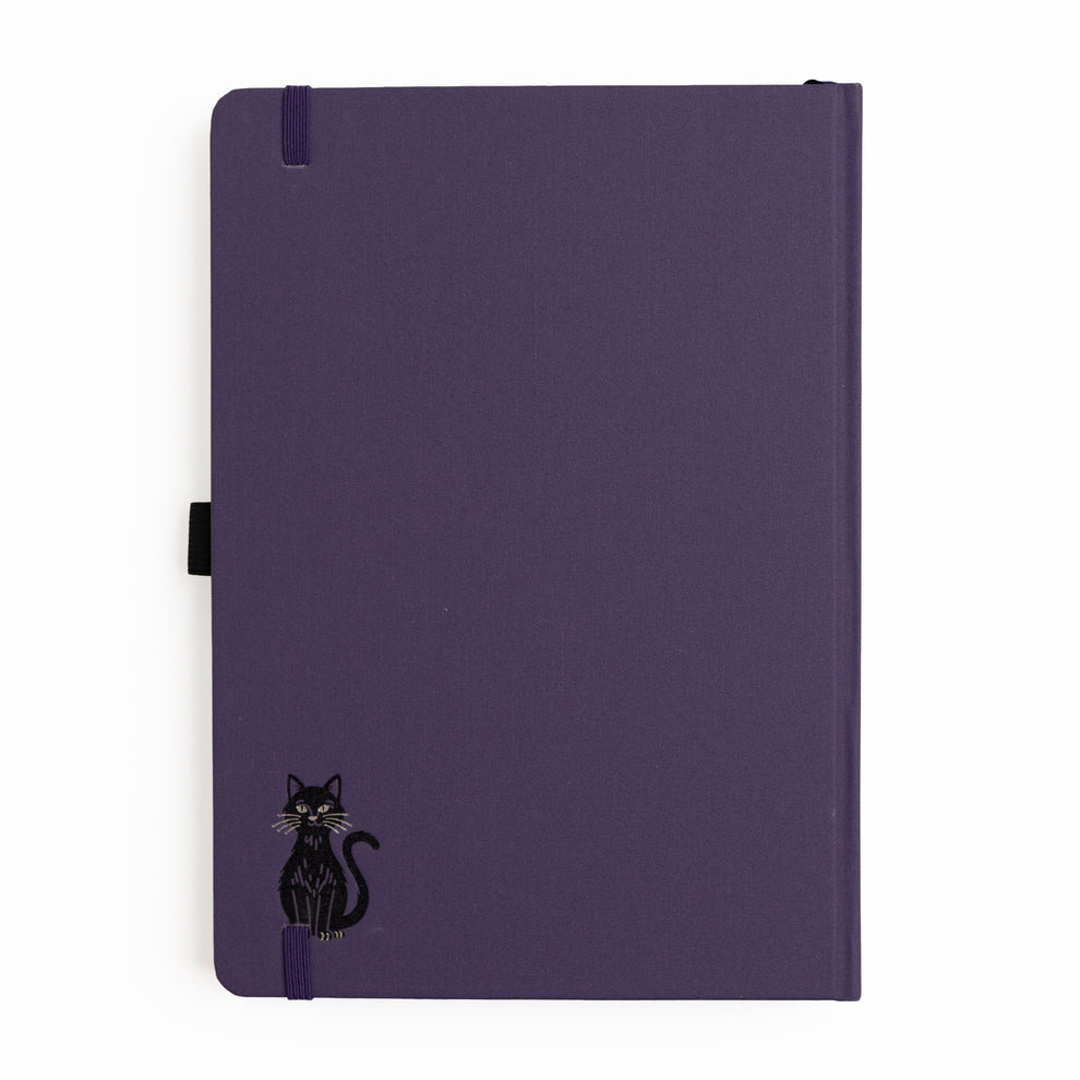 The Bewitched Notebook captures the playful spirit of Halloween with a charming black cat perched atop a broomstick beneath a crescent moon, surrounded by twinkling stars and fluttering bats.