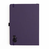 The Bewitched Notebook captures the playful spirit of Halloween with a charming black cat perched atop a broomstick beneath a crescent moon, surrounded by twinkling stars and fluttering bats.