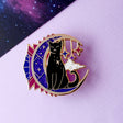 This celestial Art Deco Moon Cat is perfect for cat lovers everywhere!

It features a black cat standing on a moon filled with purple art deco shapes, with falling stars in the background.

The pin is secured by two purple heart backs and comes on a special ‘Art Deco’ Glitter Punk backing card, making it perfect for a gift or to keep as a special treat for yourself.

This pin is part of my Art Deco Cats collection – 8 enamel pins based on the fabulous 20th century visual arts movement. 

Measurements: 45mm