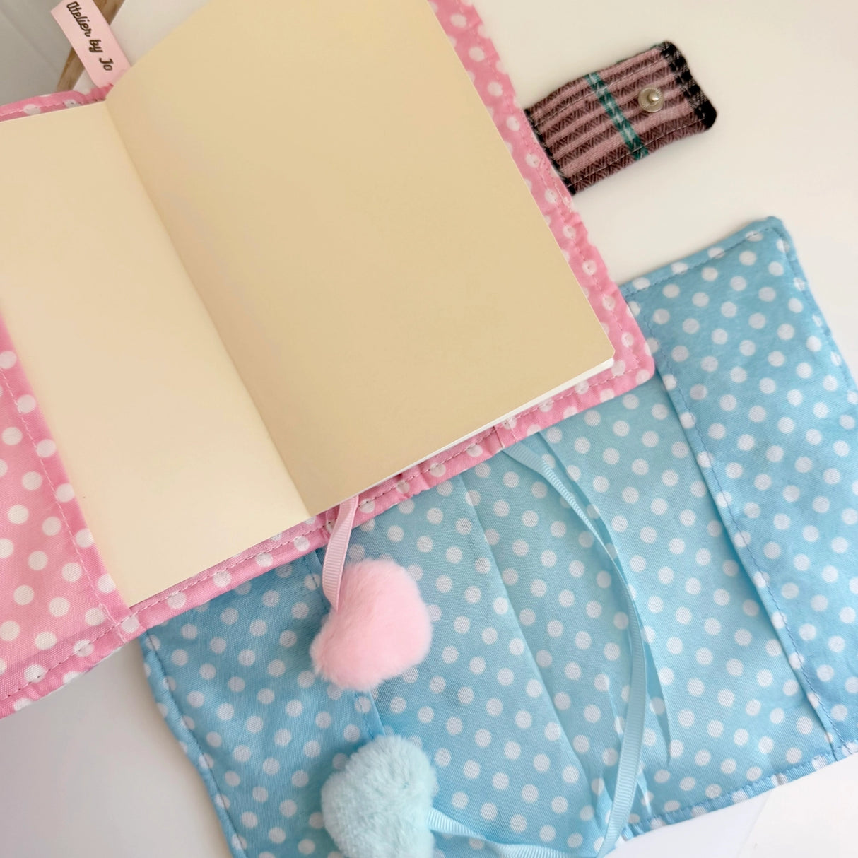 Elevate your journaling experience with these soft and cozy journal covers, designed to protect and personalize your daily diary. Each cover features beautiful blue and pink patterned fabric with thoughtfully sewn details and a secure metal button clasp to keep your pages safe. Includes matching ribbon bookmarks for easy navigation. Available in both A5 and A6 sizes to fit your preferred journal dimensions. The perfect companion for your daily routine and creative practice.
