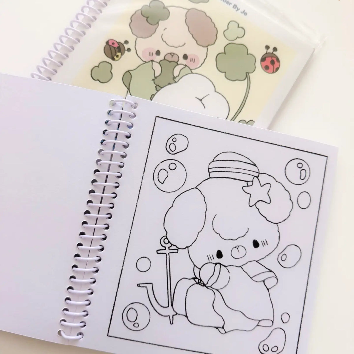 Cozy Creativity Anywhere with the Atelier by Jo Pocket Coloring Book! ✨

Bring Cotton and Pluto along on your everyday adventures with this adorable Pocket Coloring Book featuring simple and cozy Atelier by Jo character pages! Filled with 20 original illustrations in a compact 4 x 5 inch format, this spiral-bound mini coloring book is designed for relaxing, stress-free coloring anytime and anywhere.

Featuring sweet character moments, cute everyday scenes, and easy-to-color designs, this collection is perfe