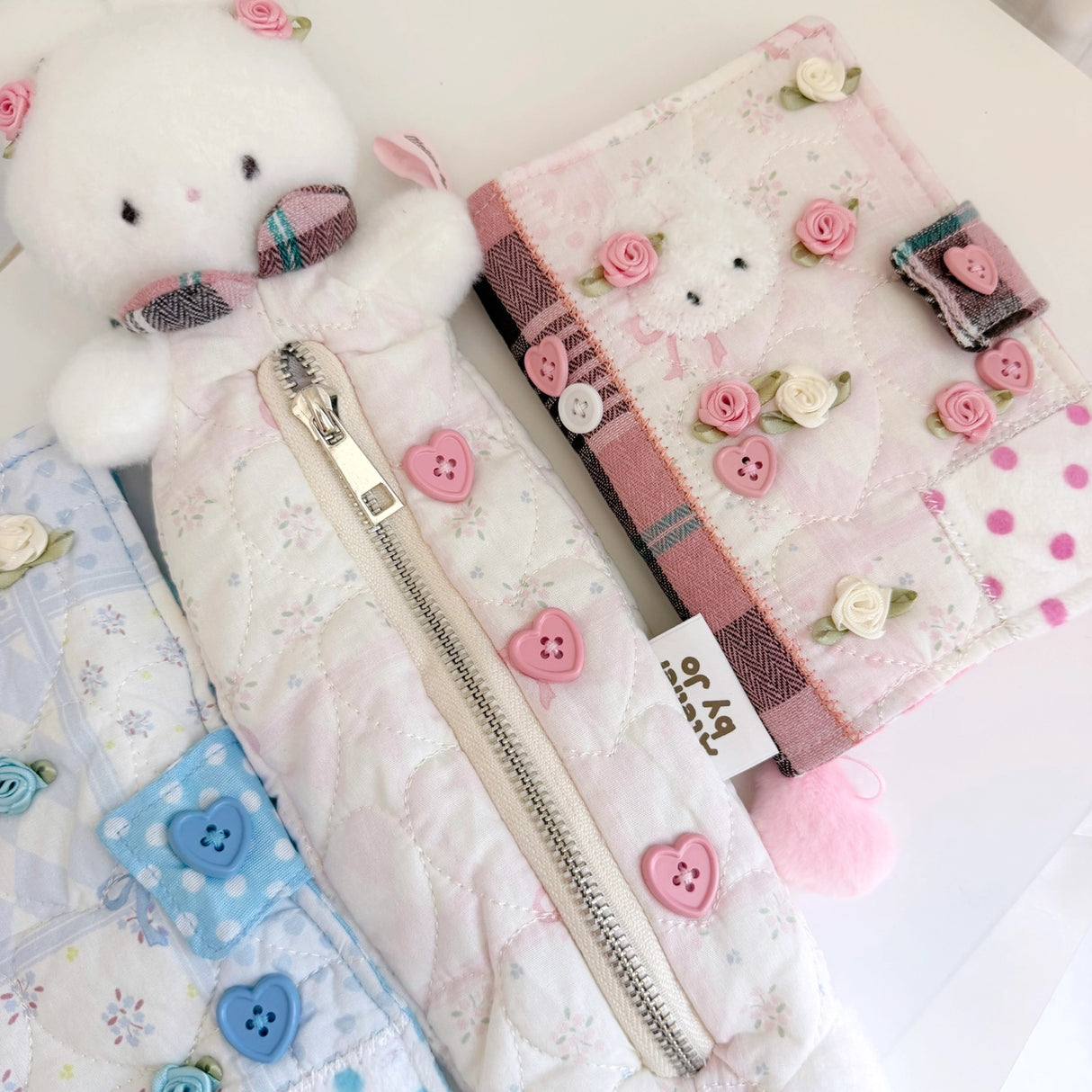Atelier by Jo Soft Pink Pencil Pouch

Keep all your journaling essentials organized in one adorable pouch. This soft pink pencil case features charming Cotton the bunny button accessories, perfect for holding pens, pencils, markers, tape, rulers, and more. The gentle fabric and cute design make it an ideal companion for your creative projects and daily planning.