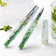 BENU Cocktail Hour Fountain Pen - Mojito

Inspired by the classic Mojito cocktail, this pen combines a transparent acrylic body with silver, green, and golden sparkling particles in a lively faceted design that beautifully interacts with light. The diamond-cut inspired surface creates depth, reflections, and movement across the material, giving the pen a fresh, glass-like appearance reminiscent of ice, lime, and sparkling summer cocktails. Bright, energetic, and refreshing, Mojito brings a playful yet sophi
