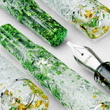 BENU Cocktail Hour Fountain Pen - Mojito

Inspired by the classic Mojito cocktail, this pen combines a transparent acrylic body with silver, green, and golden sparkling particles in a lively faceted design that beautifully interacts with light. The diamond-cut inspired surface creates depth, reflections, and movement across the material, giving the pen a fresh, glass-like appearance reminiscent of ice, lime, and sparkling summer cocktails. Bright, energetic, and refreshing, Mojito brings a playful yet sophi
