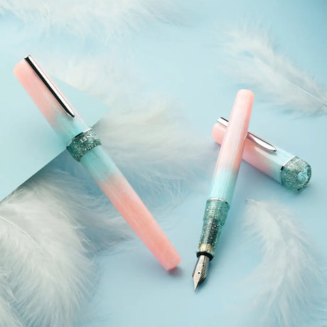 BENU presents the newest Haute Collection — a line of elegant, fashion-inspired pens that blend classic charm with bold, modern flair. The designs include both subtle and vibrant styles, showcasing BENU’s signature glitter and color artistry. Each pen features a faceted body with alternating wide and slender facets, complemented by either gold-plated or chrome-plated trims for a sleek, timeless look.

Soft shades of rose and mint melt together in Perle, accented by a sparkling band. As fresh as spring light