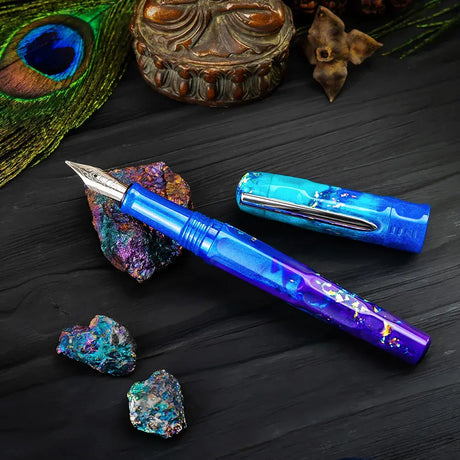 BENU Talisman Fountain Pen - Peacock Ore

Peacock Ore, with its spectacular iridescent tarnish effect, is one of nature’s most colorful minerals. Those who believe in the healing powers of crystals call it the “stone of happiness”. Believed to head us in positive directions and help channel happiness onto others, crystal enthusiasts claim this to be a truly uplifting stone.&nbsp;

Drawing inspiration from certain tales of yore, we set out to convey these stories not only in the color and style of each pen, 