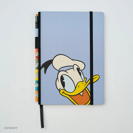 This medium notebook includes 160 pages of 100GSM blank paper and a matte hardcover featuring Donald Duck and Daisy Duck. It also has a built-in pencil holster that comes loaded with a Donald Duck Blackwing pencil.