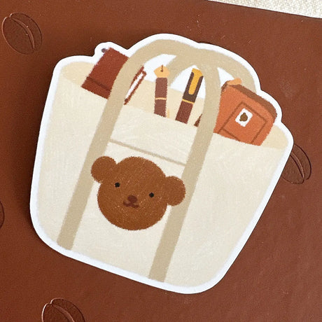 Bloom Paper Studio Die Cut Sticker - Choco's Planner Bag

Choco's tote bag contains his planner pouch, fountain pens, and traveler's notebook!

made with:
- premium matte sticker paper
- weatherproof
- 2.4"x2.4"

Note: Colors on screen may appear slightly different on paper. By purchasing, you have acknowledged reading this disclaimer.