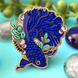 Celebrate your love for betta fish with this blue betta fish pin!

✦ Hard enamel
✦ Shiny gold metal
✦ Screen-printed details
✦ 1.25 inches
✦ 2 Posts for extra security
✦ Rubber backings
✦ Back stamped for authenticity

Comes packaged on a backing card!&nbsp;