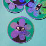 Product description
A black cat with a clipped ear wears a sparkly flower around their face. Truly, the rarest bloom. This 3" super sparkly glitter sticker is purrfect for adorning water bottles, laptops, and more. Watch how it catches the light!