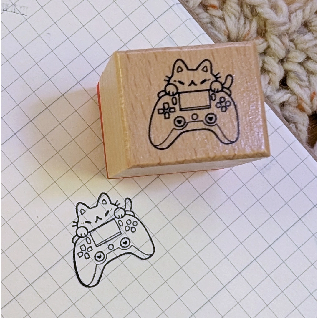 A small wood stamp of a little gamer kitty for your planner and scrapbooking needs. Each stamp measures approximately 1 x 0.75 inch.
