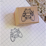 A small wood stamp of a little gamer kitty for your planner and scrapbooking needs. Each stamp measures approximately 1 x 0.75 inch.