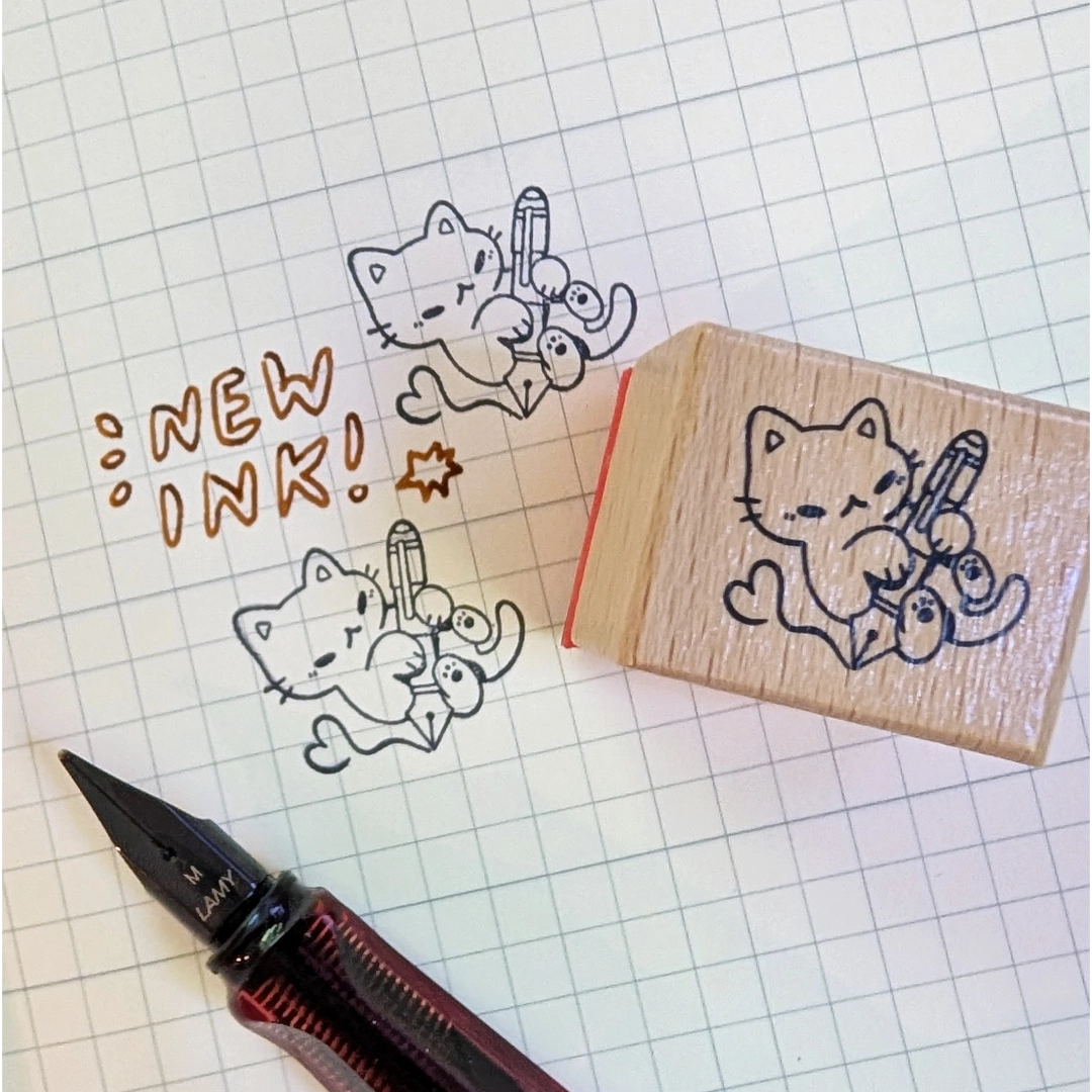 A small wood stamp of a kitty playing with a fountain pen for your planner and scrapbooking needs. Each stamp measures approximately 1 x 0.75 inch.
