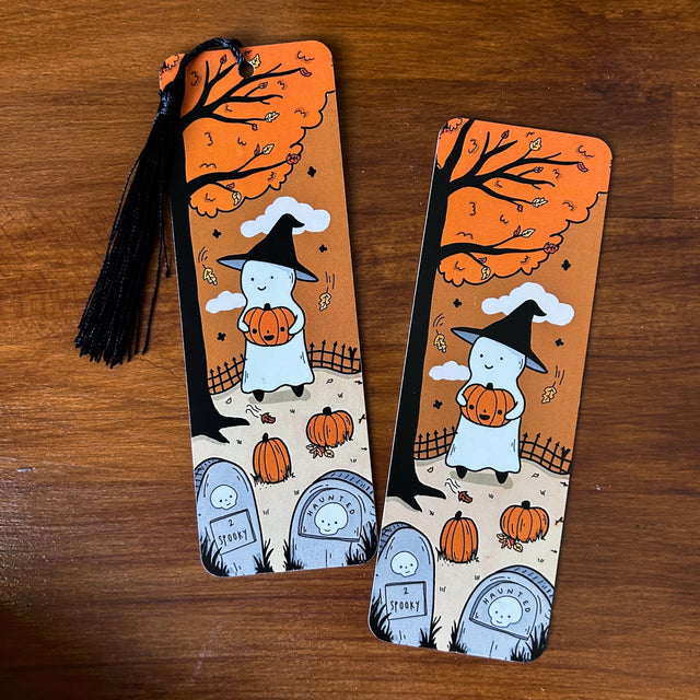 Bookmark of a ghost visiting the graveyard with a pumpkin on a chilly day.