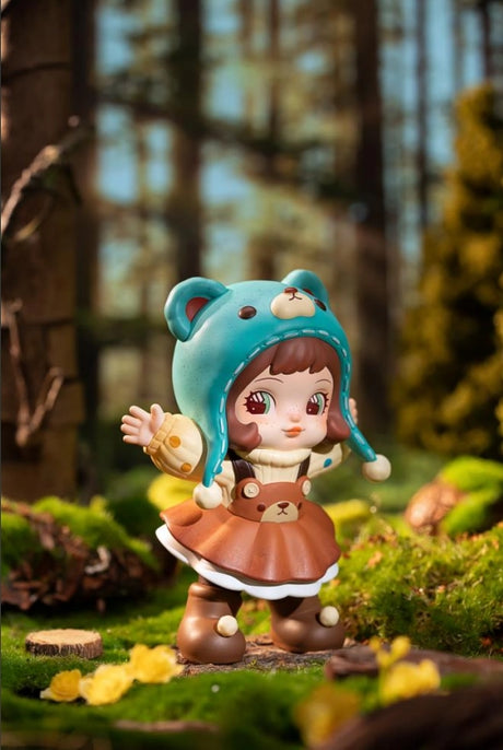 Charline Forest's Children Blind Box Toy figure of a girl with a blue hat and brown dress standing in a forest setting