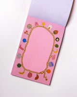 Charmed By Clem Notepad by Clem & Co.

Clem the Bun loves to make charm bracelets for all her friends! However, she kept forgetting which of her friends she had already given them to, so she made a notepad to keep track. Jot down things you don't want to forget either on this charming little notepad!