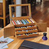 Our dramatic pen case for collectors, with new upgrades to accommodate larger styles. Part of the pleasure of being a pen lover is visual; a certain satisfaction ensues from being able to admire your favorites (and have others do the same). Our Lock and Key Pen Case offers more than an attractive space for displaying your prize pens—it also keeps your collection protected and free from dust. Unlock the wood inlay doors and lift the hinged protective glass lid to reveal the 4 drawers, each with 10 suede-line