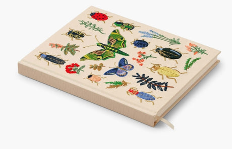Our embroidered sketchbook is a large, hardcover journal with 108 unlined pages of thick paper perfect for sketching, drawing, and journaling. The cover is wrapped in cream book cloth and embroidered with the beetles and bugs of our Curio print with metallic gold accents. An attached grosgrain ribbon bookmark will save your place.