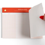Turn your to-dos into ta-das with the Dream Big Notepad. This 6x8” desk pad features 75 grid pages organized into columns for Doing, Done, and Double-Checked—perfect for tackling big goals one step at a time. With smooth 120gsm paper, gold posts, and a bold red-orange header, it’s designed to keep you motivated and organized. The top-bound format and perforated pages make it easy to tear off and take with you. Ideal for goal-setters, planners, and productivity lovers. Makes a great gift for students, cowork