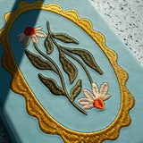 Embroidered Daisy Frame Hardbound Notebook

A premium hardcover notebook featuring precision embroidery on a vegan leather cover. Designed for everyday use, it includes smooth-lined pages, a Smythe-sewn layflat binding for effortless writing, and a satin ribbon to mark your place.

New inside page design
Soft Touch Embroidered Hardcover
5.75" x 8.25"
144 Lined Pages
Contrast Endpages
Satin Ribbon Bookmark &amp; Pen Loop
