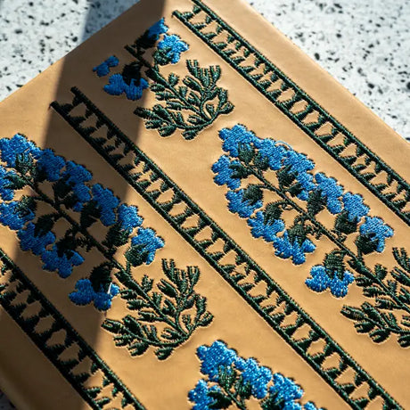 Embroidered Delphinium Flower Hardbound Notebook

A premium hardcover notebook featuring precision embroidery on a vegan leather cover. Designed for everyday use, it includes smooth-lined pages, a Smythe-sewn layflat binding for effortless writing, and a satin ribbon to mark your place.

New inside page design
Soft Touch Hardcover
5.75" x 8.25"
144 Lined Pages
Contrast Endpages
Satin Ribbon Bookmark &amp; Pen Loop