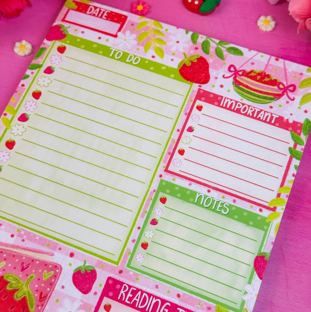 Stay organized in style with this adorable Strawberry Book Stack Daily Planner Notepad! Perfect for jotting down your daily tasks, goals, and bookish ideas, this notepads brings a pop of personality to your desk. Featuring a sturdy cardboard back and premium 70lb. uncoated paper, it's built to last through all your planning adventures.&nbsp;

✦ DETAILS ✦

Size: 5.5" x 8.5"

70 lb. Paper Uncoated

Padded With Cardboard Back

50 Sheets
No magnet backing