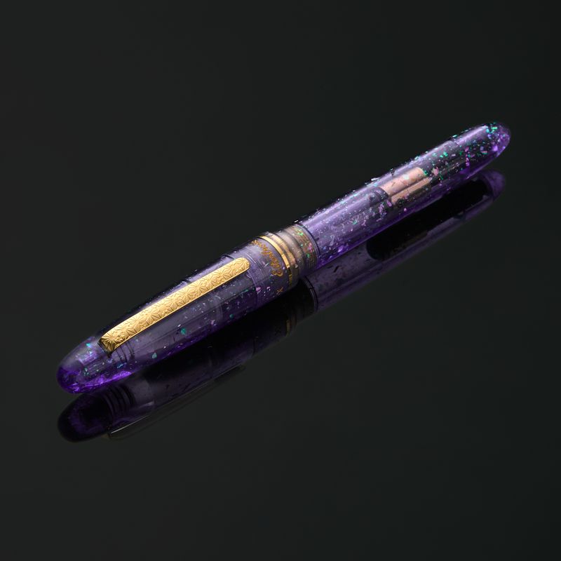 Esterbrook x Sakuradragon Sakura Street Estie Fountain Pen

Created with artist Cindy Duong of Sakuradragon, the Sakura Street Estie brings her imaginative illustrated world to Esterbrook's traditional Estie fountain pen. Its U.S.-blended material combines translucent purple with colorful glitter sparkle, while the custom clip is etched with Cindy's Sakura pattern. Dual Esterbrook and Sakuradragon engraving and a gold-plated converter finish the design. Each pen arrives in special packaging with Japanese gi