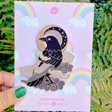 This fabulous patch features a black crow surrounded by grey glittery clouds, and a starry moon with grey backgrounds.

Beautifully woven with black, white, grey & gold threads, this fabulous patch with brighten up any coat, bag or hat!

Measurements: 70mm x 90mm