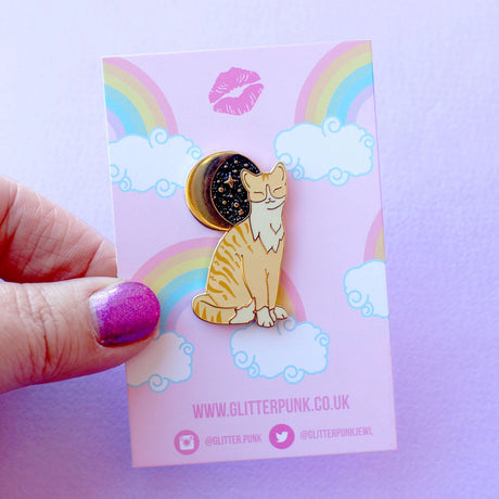 Glitter Punk - Ginger Cat Enamel Pin

Due to popular demand, here is a Ginger Cat enamel pin in a classic Glitter Punk style! Made from gold hard enamel, this 36mm cat has screen printed details, and sits under a glittery moon. It is secured with two pink rubber clasps.