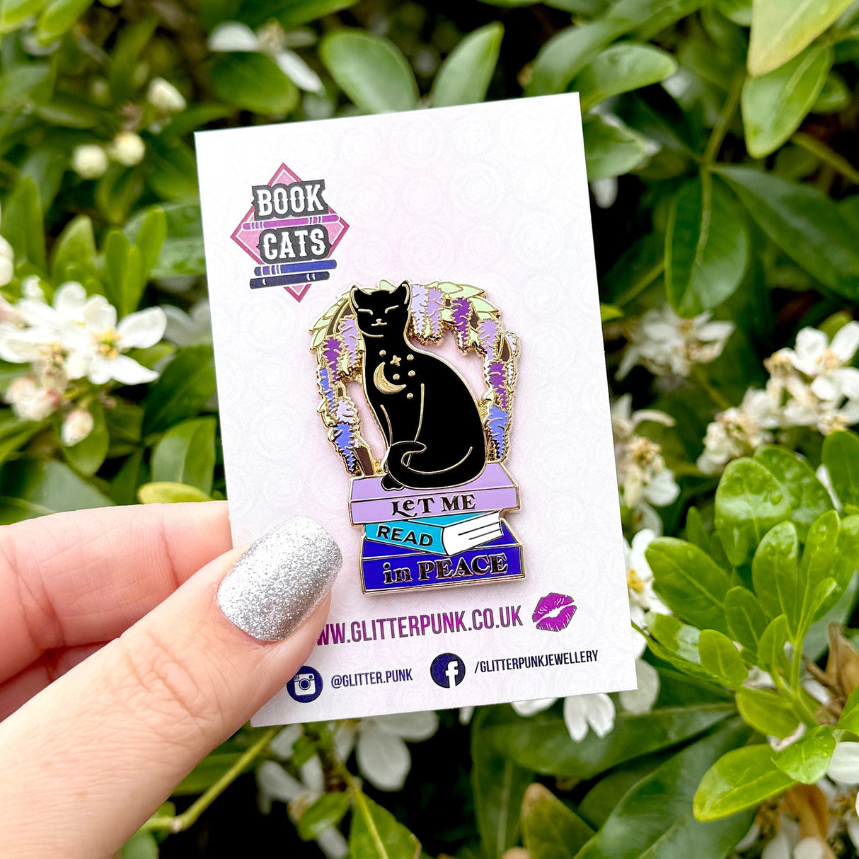 We’ve all had moments where we wish the world would just leave us alone so we can get lost in a good book! This gorgeous enamel pin features a black cat underneath an arch of wisteria, sitting on a pile of books with the slogan ‘Let me Read in Peace’

Measurements: 44mm (1.73”)