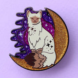 Calling all owners of a long haired pointed / meezer cats! This super cute design features the cat sitting in front of a sparkly moon with a glittery, starry sky in the background.

The pin is 40mm (1.57”) tall, and is made from gunmetal hard enamel, with glitter and UV printed details. It's secured with 2 pink clutches to keep the pin in place.