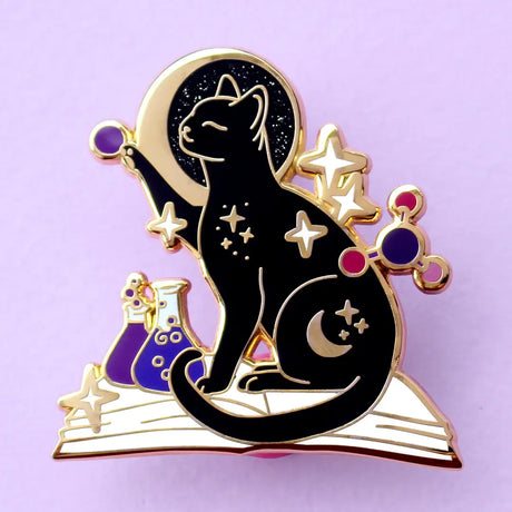 If you’re passionate about science and partial to cats, this awesome pin is perfect for you! It features a black cat sitting on a book and playing with atom parts. It also features a glittery moon and two beakers filled with purple liquid.

The pin is 42mm (1.65”) tall, and is made from gunmetal hard enamel, with glitter and UV printed details. It's secured with 2 pink clutches to keep the pin in place.