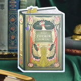 A humorous book-style greeting card that’s sure to spark a smile. This dark green and yellow vintage design features hand-illustrated chickens framed in ornate gold detailing with the playful phrase “Just chickin’ in on you.” A witty and collectible foil-pressed stationery piece that adds a touch of humor to your display.

Product Details:
- Dimensions: 5" x 7"
- Die-cut vintage book cover
- Hand-illustrated with gold foil details
- Blank interior
- Offset and foil printed
- Envelope included