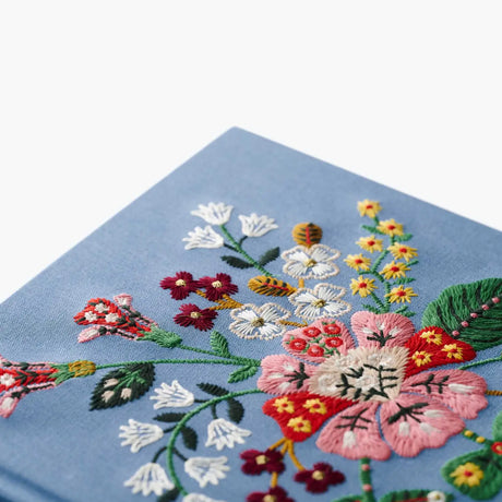 Our embroidered sketchbook is a large, hardcover journal with 108 unlined pages, perfect for sketching, drawing, and journaling. The cover is wrapped in blue book cloth and embroidered with our Gracie florals. Inside, an attached grosgrain ribbon bookmark will save your place.