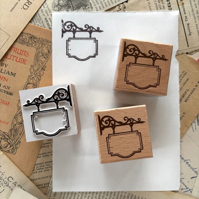 The Creeping Moon - Hanging Shop Sign Rubber Stamp

One rubber stamp of a blank hanging shop sign!&nbsp;

Each stamp is made with beech wood and measures roughly 1.5L x 1.5W x .8H" (38x38x20mm). The writable area on the sign measures about 23x15mm.