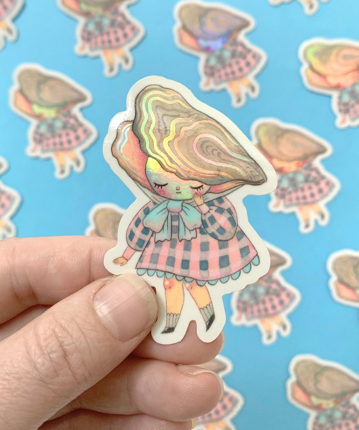 "Pearl" Vinyl Sticker made from Hannakin illustration with subtle holographic accents (on the face and oyster shell) with shiny gloss finish.

Made from a durable waterproof vinyl with a matte laminate that protects it from scratching, rain and sunlight.