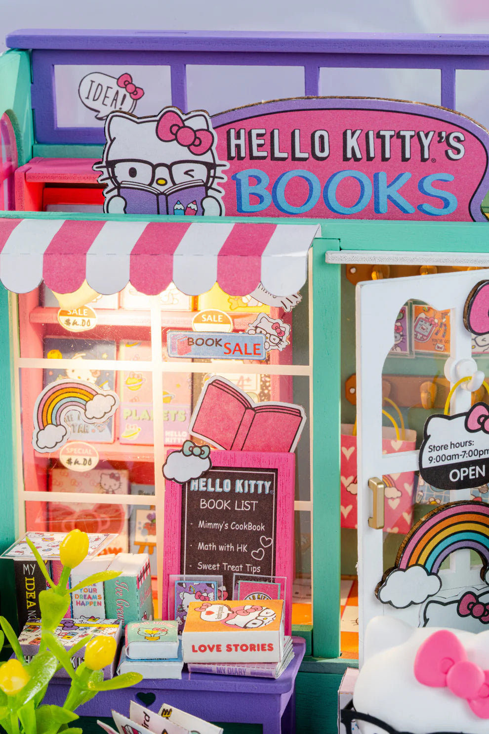 Step into the charming world of Hello Kitty with this delightful miniature house kit, where she runs her very own bookstore. Filled with tiny books, adorable gifts, and colorful gift bags, this kit is decorated in Hello Kitty's iconic style. The charming "open" sign welcomes you into the cozy shop, where a little lamp lights up the interior, creating a warm and inviting atmosphere. Perfect for fans and crafters alike, this kit offers hours of fun and a beautiful keepsake to treasure.