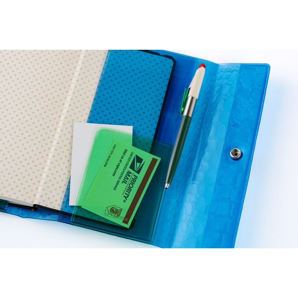 Color-blocked in blue and green, the pocket in green adds a pop of color and is finished with an embossed shrink leather texture. The two colors and patterns overlap to create depth in the design.

The pen hook holds a pen by its clip. This cover does not include bookmarks.